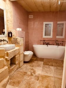 e bagno con vasca, servizi igienici e lavandino. di Talbot House by Talbot & Bons a Luqa