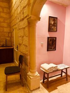 a room with a table and a chair and a pillar at Talbot House by Talbot & Bons in Luqa