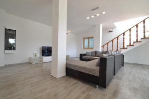 a living room with a couch and a staircase at Villa Pistan in Murvica
