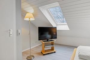 ein Wohnzimmer mit einem TV und einem Dachfenster in der Unterkunft Urlauberdorf Urlauberdorf 33b in Boltenhagen