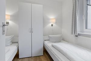Dieses weiße Zimmer verfügt über 2 Betten und ein Fenster. in der Unterkunft Urlauberdorf Urlauberdorf 33b in Boltenhagen