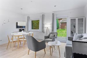 a white living room with a table and chairs at Urlauberdorf Urlauberdorf 42a in Boltenhagen