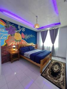 een slaapkamer met een bed en een schilderij aan de muur bij #dganuresthouz Kuala Terengganu, Malaysia in Kuala Terengganu