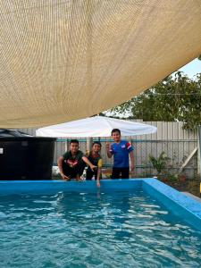 un groupe de personnes debout dans une piscine dans l'établissement Hana homestay D Yan Bedroom3, à Yan