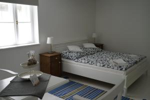 Vértessy ház في كيزتيلي: غرفة نوم بيضاء مع سرير وطاولة