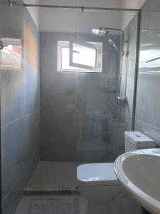 a bathroom with a shower and a toilet and a sink at Vila M Vera Studios and Apartments in Durrës