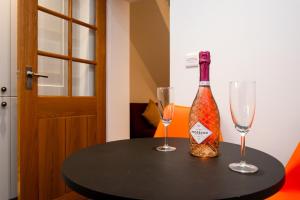 Una botella de vino y dos copas en una mesa. en Casa One Hundred - A Beautiful 4 Bed House on the Beach Front, en Swansea