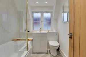 a bathroom with a toilet and a sink and a shower at Kestrel Gardens Dunmow in Great Dunmow