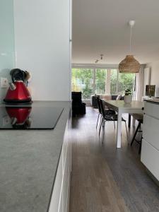 a kitchen and living room with a table and a dining room at Recent en lichtrijk duplex-appartement te Wenduine in Wenduine