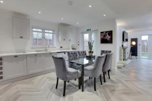 a kitchen and dining room with a table and chairs at Kestrel Gardens Dunmow in Great Dunmow