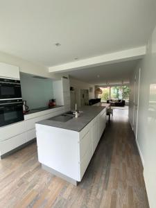 una cocina con una isla blanca en una habitación en Recent en lichtrijk duplex-appartement te Wenduine en Wenduine