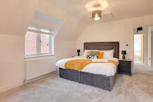 a bedroom with a large bed and a window at Kestrel Gardens Dunmow in Great Dunmow