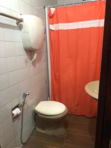 a bathroom with a toilet and a shower curtain at Amaaral in Rocha