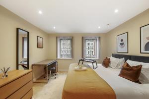 a bedroom with a large bed with a desk and a desk at LiveStay-Stunning 2 Bed 2 Bath Apartment in Maida Vale in London