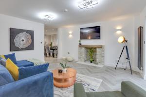 a living room with a blue couch and a table at Kestrel Gardens Dunmow in Great Dunmow