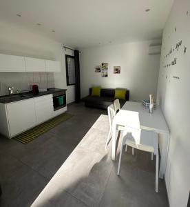 eine Küche und ein Esszimmer mit einem weißen Tisch und Stühlen in der Unterkunft Case Costy in Aci Castello