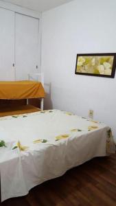 - un lit avec une couverture blanche dans l'établissement Amaaral, à Rocha