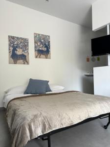 ein Schlafzimmer mit einem Bett mit drei Bildern an der Wand in der Unterkunft Case Costy in Aci Castello