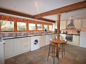 a large kitchen with white cabinets and a washer and dryer at 2 Bed in Bridgwater REXBA in Spaxton