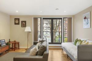 a living room with a couch and a large window at LiveStay-Stunning 2 Bed 2 Bath Apartment in Maida Vale in London
