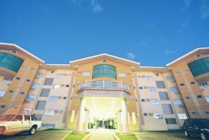 a large building with a car parked in front of it at Barbur Plaza Hotel in Ponta Grossa