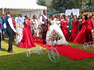 a bride and groom walking down a red carpet at INFINITE GREEN EVENTS GARDEN AND ACCOMMODATION in Dowsonville
