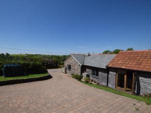 an old building with a brick driveway next to a house at 2 Bed in Croyde GCOWS in Marwood