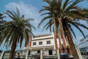 two palm trees in front of a building at Hotel SD Grand Palace, Mant Raya Road, Mant, Nearby Vrindavan, Mathura in Māt