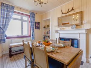 a dining room with a wooden table and a fireplace at 2 Bed in Lochinver 32364 in Oldany