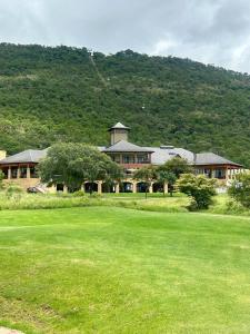a large building in front of a green field at De Marea villa in Naboomspruit