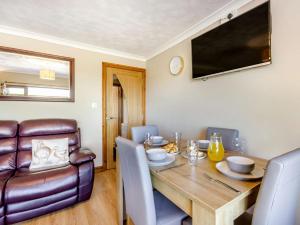 ein Esszimmer mit einem Tisch und einem Ledersessel in der Unterkunft 2 Bed in Higher Clovelly 43751 in Clovelly