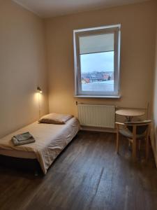 Schlafzimmer mit einem Bett und einem Fenster in der Unterkunft Hostel na Fali in Goleniów