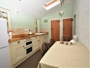 a kitchen with a table and a white refrigerator at 1 Bed in Ballantrae 45713 in Ballantrae