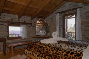 a bedroom with a leopard print bed with a mirror at Aristoteli's Stone House in Makrirrákhi