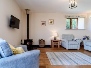 een woonkamer met 2 blauwe stoelen en een open haard bij 2 Bed in Sidmouth 50004 in Sidbury
