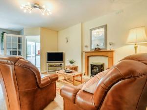 - un salon avec un canapé en cuir et une cheminée dans l'établissement 2 Bed in Cockermouth 49197, à Cockermouth