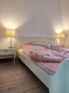 1 dormitorio con 1 cama blanca con lámpara y mesa en Watt, en Karolinenkoog