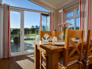 a dining room with a table and chairs and a large window at 2 Bed in Lochwinnoch 55854 in Kilmacolm