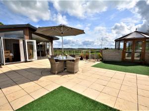 a patio with a table and an umbrella at 2 Bed in Lochwinnoch 55854 in Kilmacolm