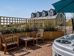 een patio met 2 stoelen, een tafel en een parasol bij 1 Bed in Weymouth 57926 in Osmington
