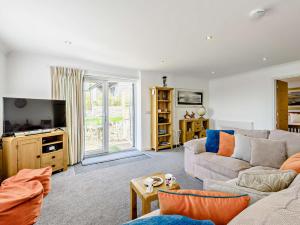 een woonkamer met een bank en een tv bij 1 Bed in Weymouth 57926 in Osmington