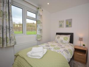 a bedroom with a bed with a green blanket and a window at 3 Bed in Moorlinch 56284 in Greinton