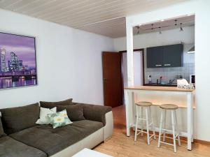 a living room with a couch and a kitchen at Cozy Apartments in Limeshain in Hainchen