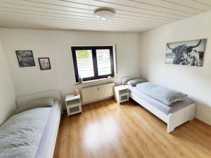 1 dormitorio con 2 camas y ventana en Cozy Apartments in Limeshain, en Hainchen
