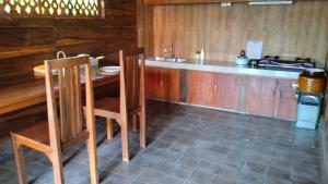 a kitchen with a counter and a table and chairs at Rumah Impian Padang Kecag in Candidasa