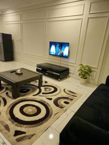 a living room with a table and a tv at Aesthetic Scenic Luxurious Apartment - Bahria Heights in Rawalpindi