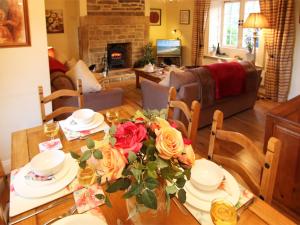 - une salle à manger avec une table et des fleurs dans l'établissement 3 Bed in Whitley Bay CN013, à Backworth