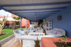 a patio with white furniture and a blue ceiling at Pool Suite Carmen in Las Palmas de Gran Canaria