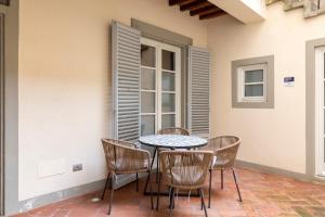 un patio con tavolo, sedie e finestra di numa I Felice Rooms & Apartments a Firenze