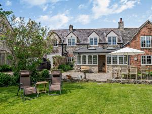 a house with chairs and an umbrella in the yard at 4 Bed in Isle of Purbeck IC101 in Corfe Castle